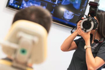 Especialista en estética dental toma una foto a un paciente de carillas dentales