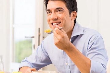 Hombre masticando con implantes dentales