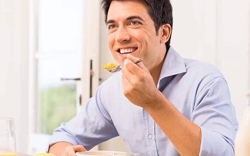 Hombre masticando con implantes dentales