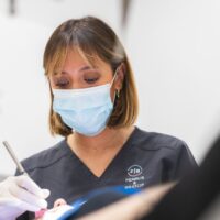 Aparece una doctora limpiando implantes dentales