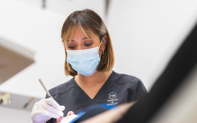 aprende a limpiar tus implantes con los consejos de la doctora de la Clínica Ferrus & Bratos Aparece una doctora limpiando implantes dentales