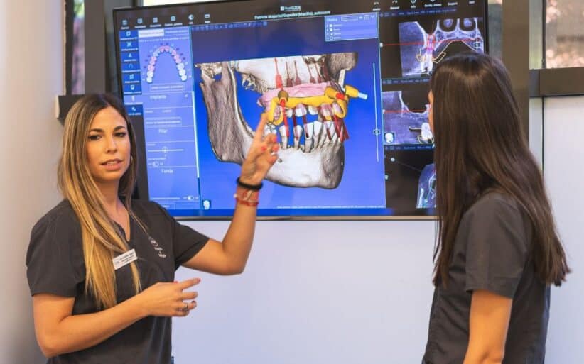 sintomas-rechazo-implantes Dos doctoras Especialistas en Implantes dentales explicando el proceso de rechazo de sintomas de implantes dentales
